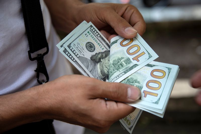 FILE PHOTO: A man counts U.S. dollars in Tehran, Iran July 7, 2019. Nazanin Tabatabaee/ WANA (West Asia News Agency) via REUTERS. 